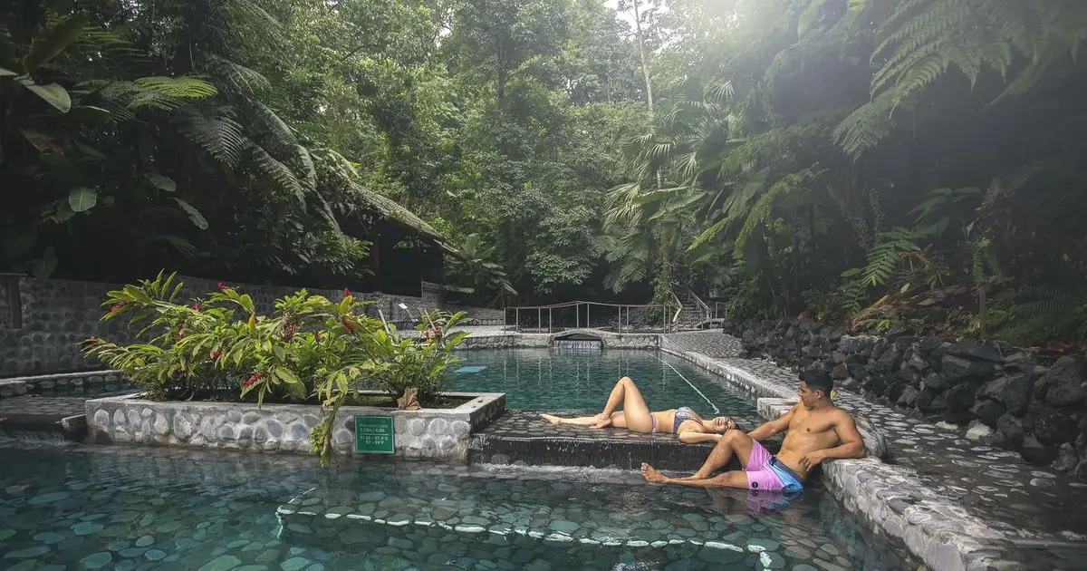 Shaded thermal pool under rainforest trees at Ecotermales hot springs day pass near La Fortuna, Costa Rica